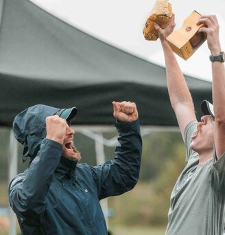 Two men celebrating in at a race in the rain.